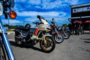 A row of motorcycles parked outdoors under a blue sky